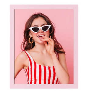 Custom framed print of woman in striped red and white top with sunglasses on pink background