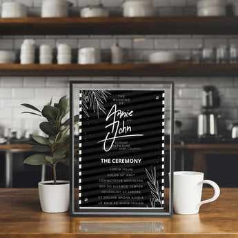 Custom framed wedding invitation print with black and white design on kitchen counter