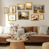 Gallery wall with gold frames featuring nature and landscape art above a cozy beige sofa.
