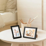 Personalized photo frames with family pictures on a round bedside table, cozy decor style