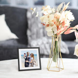 Custom photo frame with beach couple next to modern floral vase on living room table