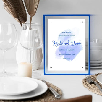 Custom blue acrylic frame displaying a wedding invitation on a modern dining table setup