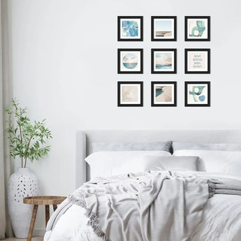 Modern bedroom with nine black-framed art prints and beach-inspired wall decor above bed