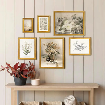 Gallery wall with gold-framed botanical art and floral prints above a wooden console table